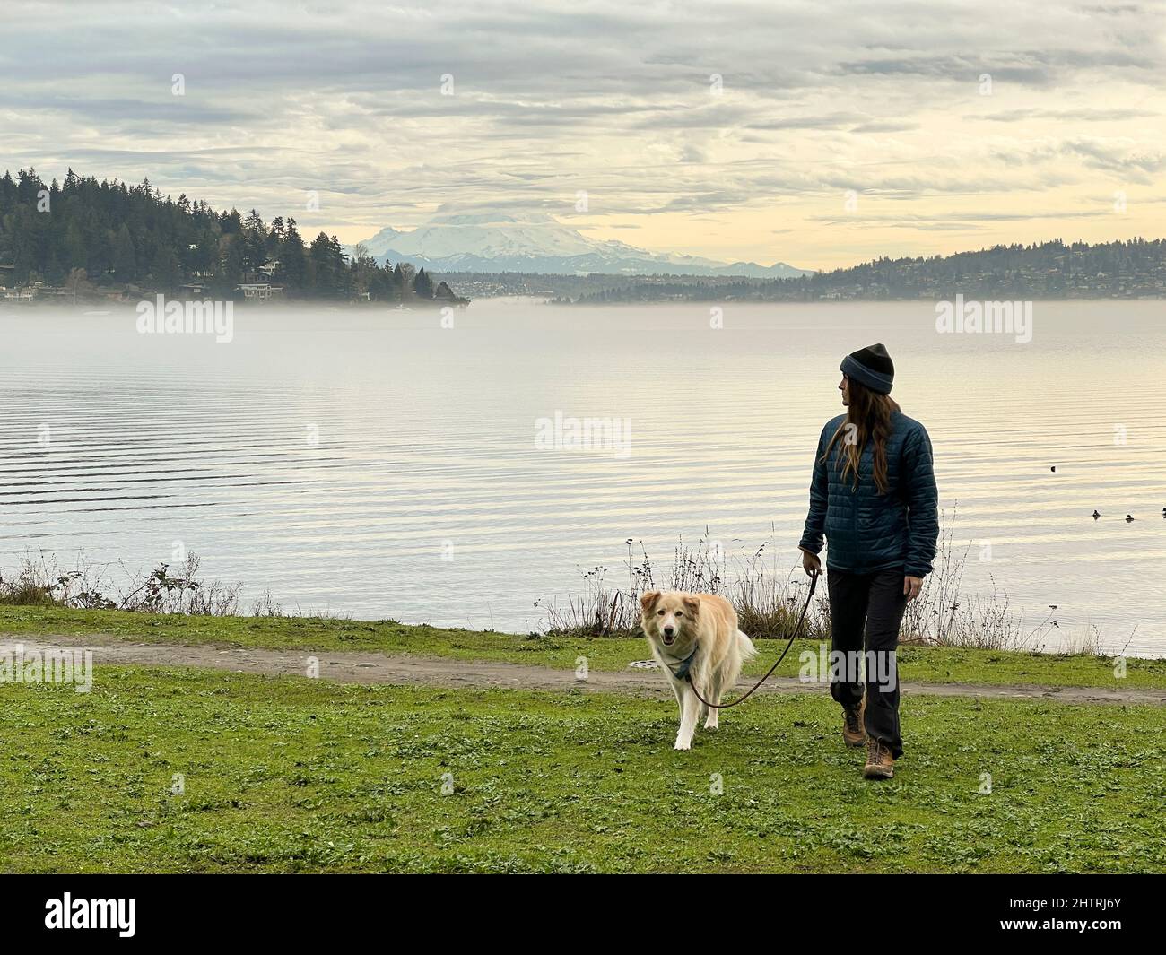 Femmina e il loro cane che cammina a Seward Park Foto Stock