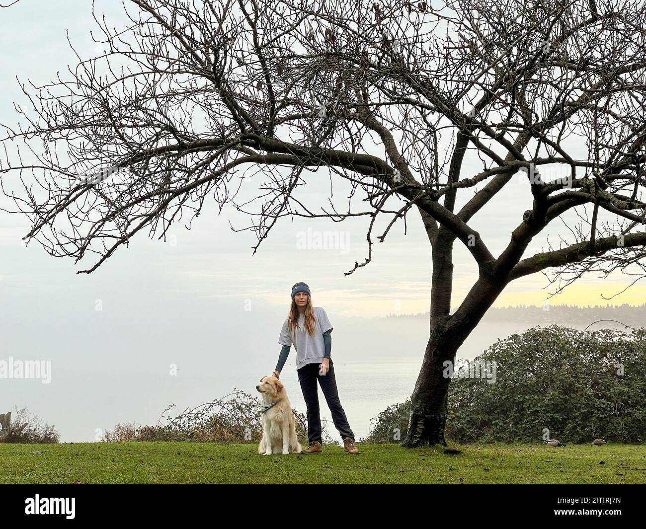 Femmina e il loro cane che cammina a Seward Park Foto Stock