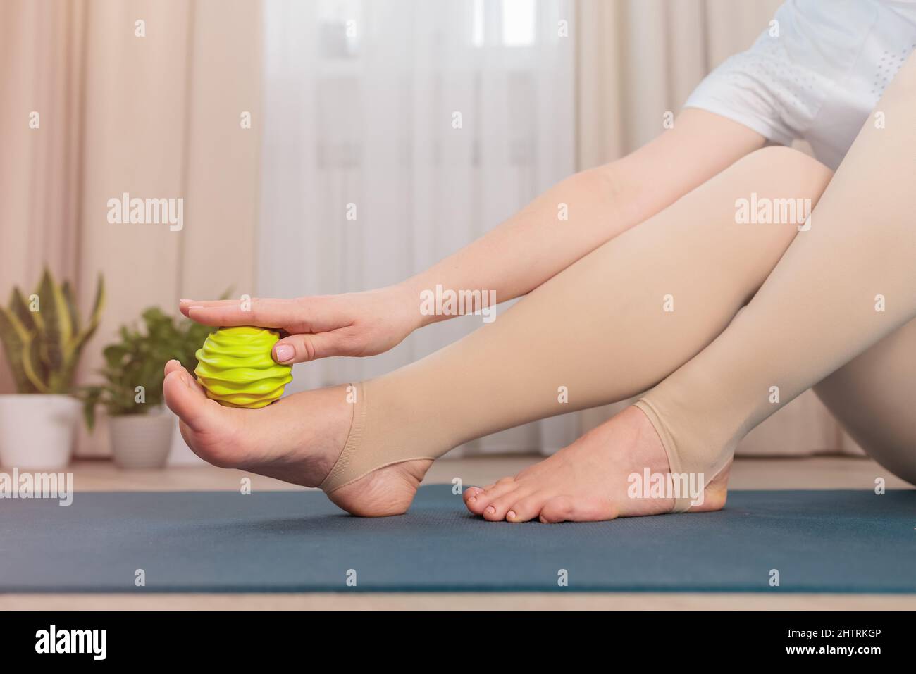 Auto-massaggio miofasciale dei piedi con una palla speciale Foto Stock