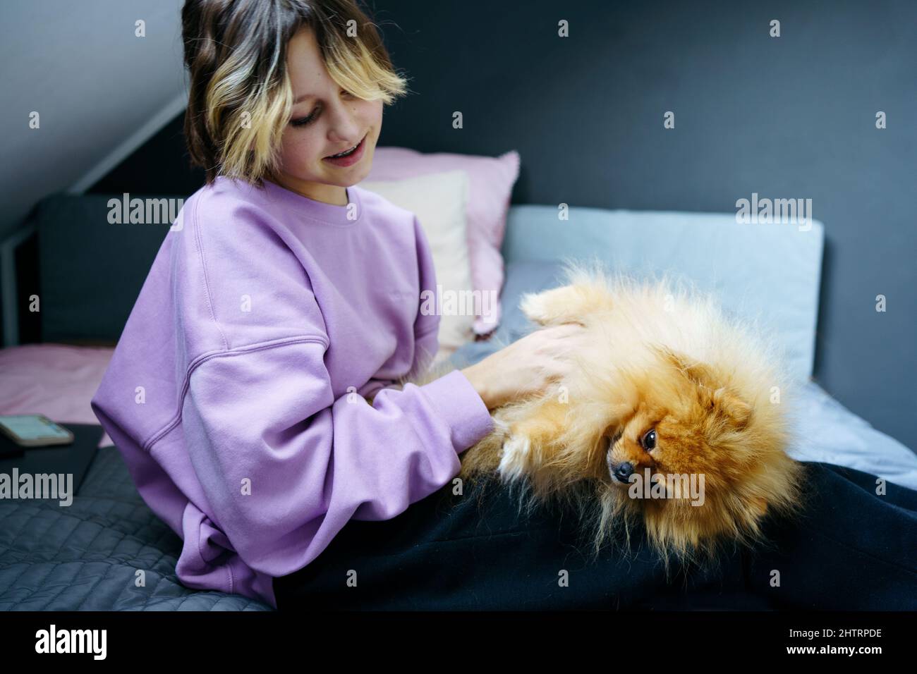 Ragazza teen proprietario che prende cura dei loro animali domestici, alimentando, grooming, gioca con il cane Foto Stock