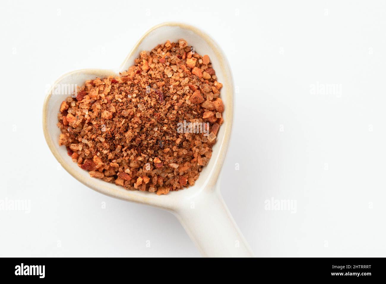 Condimento con hamburger su una cucchiaino a forma di cuore Foto Stock
