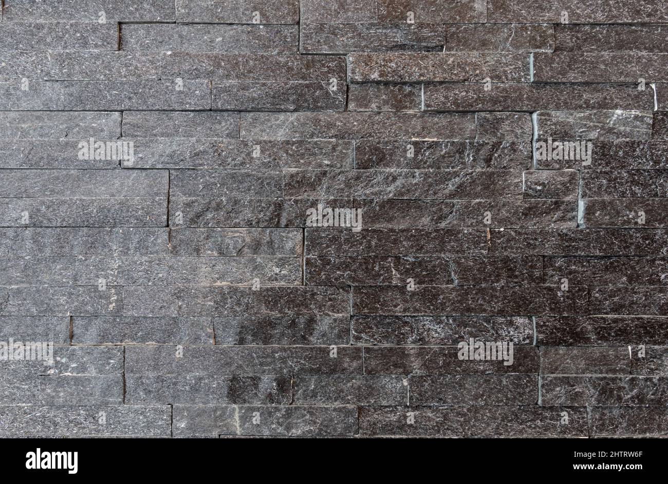 Strisce di pietra grigia. Moderno decorativo muro di pietra rivestimento texture sfondo. Foto Stock
