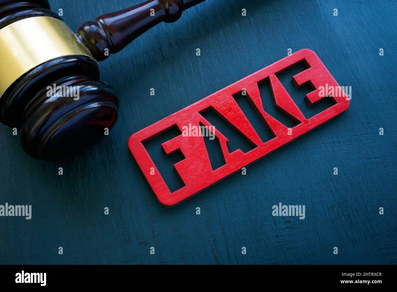 Notizie false e concetto di punizione. Gavel e piastra sulla superficie. Foto Stock