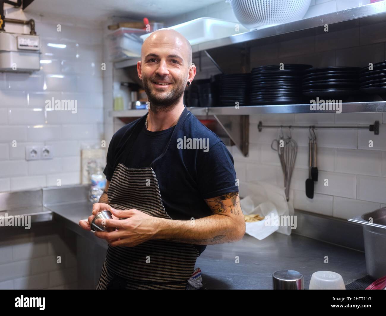 Chef con un aspetto alternativo in piedi su una cucina di un ristorante Foto Stock