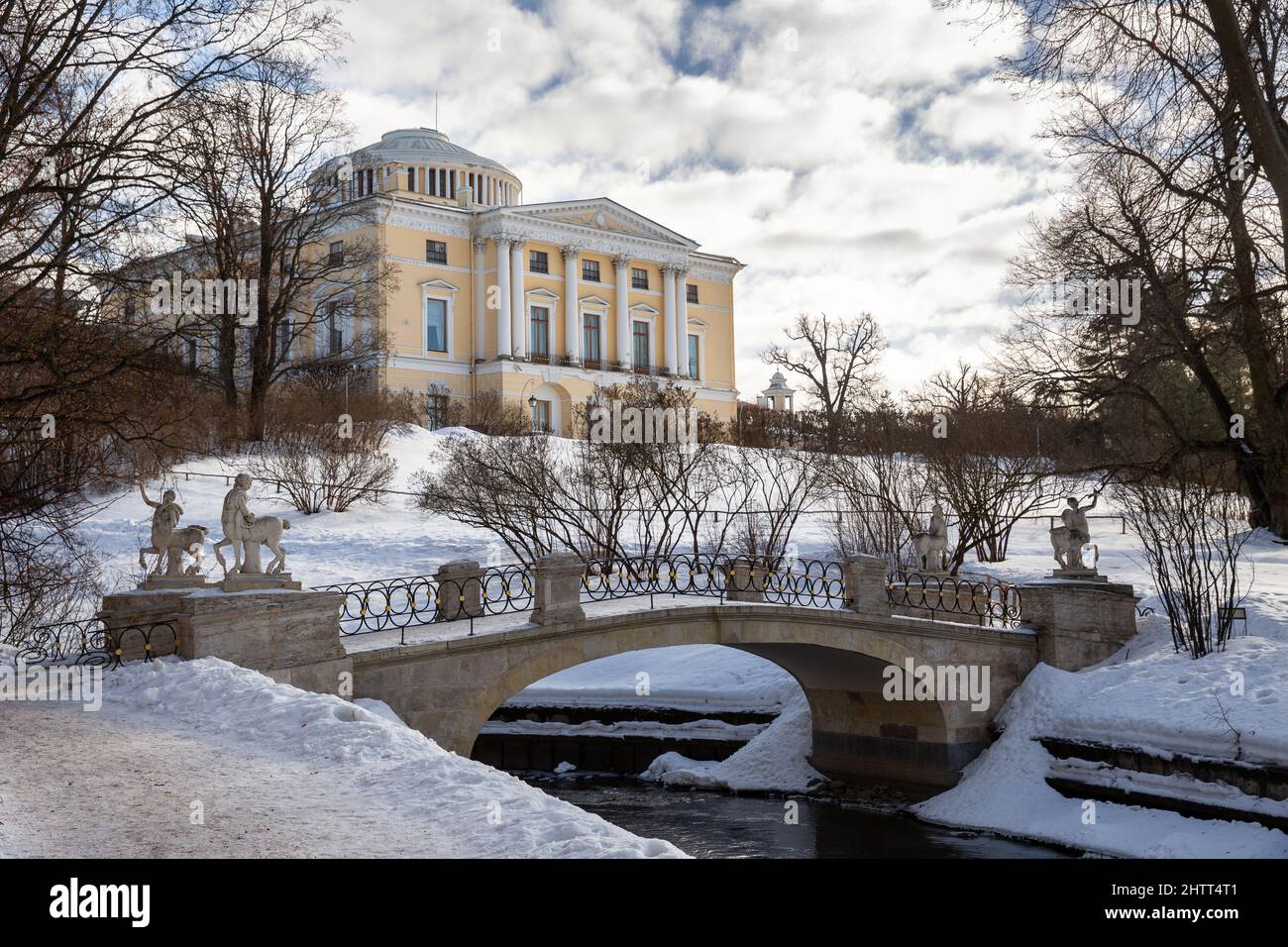 San Pietroburgo, Russia - Febbraio 2022: Palazzo Pavlovsk e Ponte Centauri attraverso il fiume Slavyanka in inverno Foto Stock
