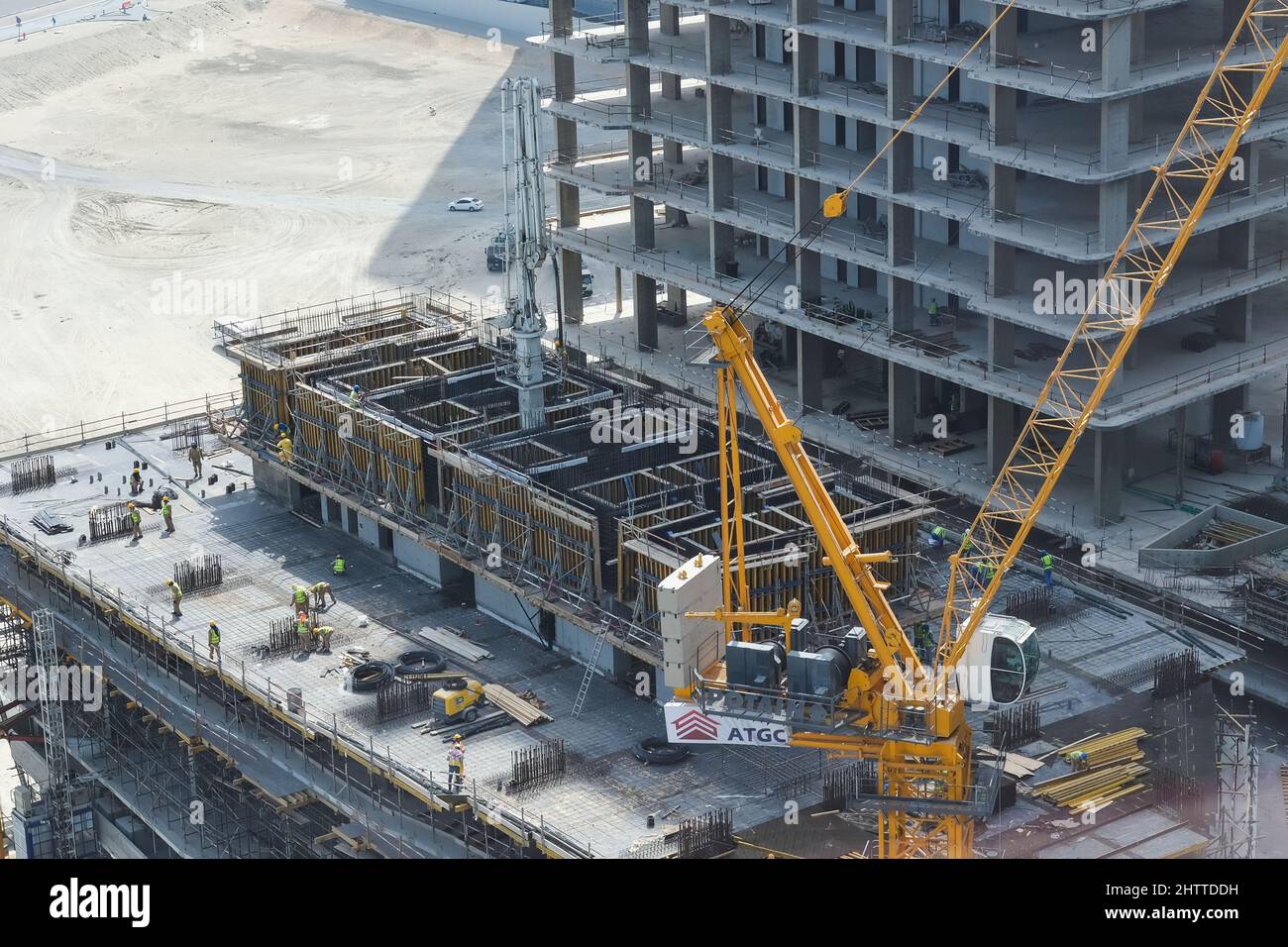 Vista dall'alto del cantiere con gruppo di costruttori sul tetto. Moderno edificio in grattacielo negli Emirati Arabi Uniti Foto Stock