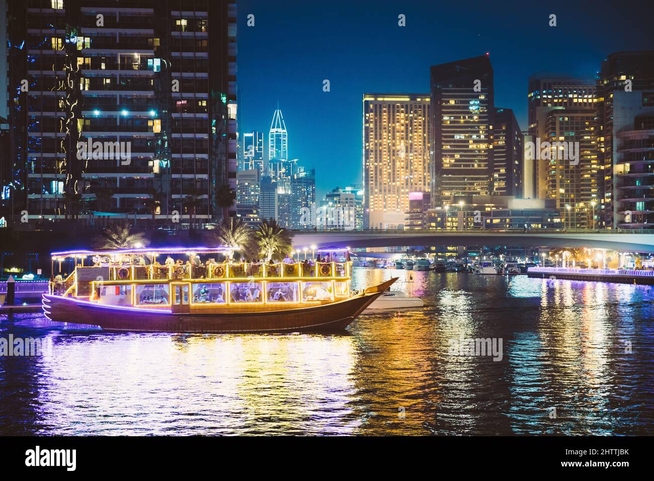Passeggiata notturna in barca turistica, barca a vela turistica sulla Marina di Dubai. La vista notturna di Dubai Marina è District in Dubai, Emirati Arabi Uniti. Notte Foto Stock