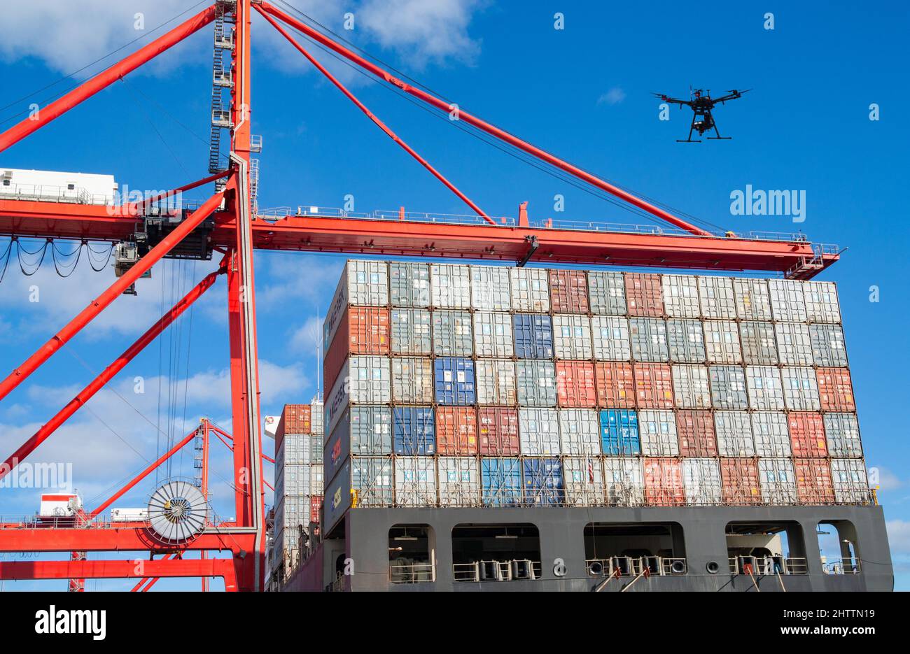 Drone che vola sopra i container di spedizione sulla nave in porto. Concetto: Tecnologia dei droni, Mar Rosso, attacco, dirottamento sorveglianza, sicurezza, attacco droni... Foto Stock