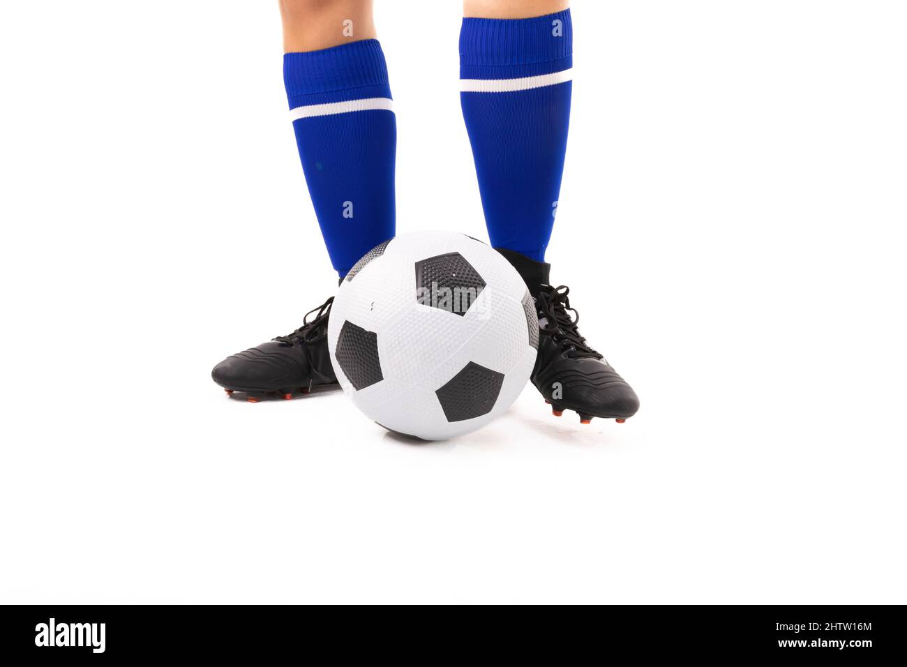 Sezione bassa di giovane donna biraciale in piedi da palla di calcio su sfondo bianco Foto Stock