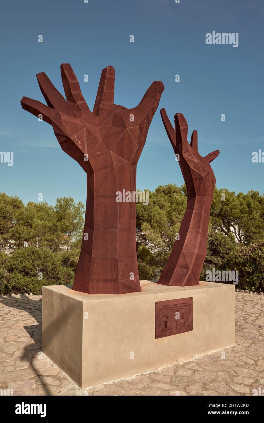 Scultura simbolo di resistenza e difesa dei valori democratici nel punto di vista del faro. Due mani che guardano il cielo a Cullera, Valencia Foto Stock