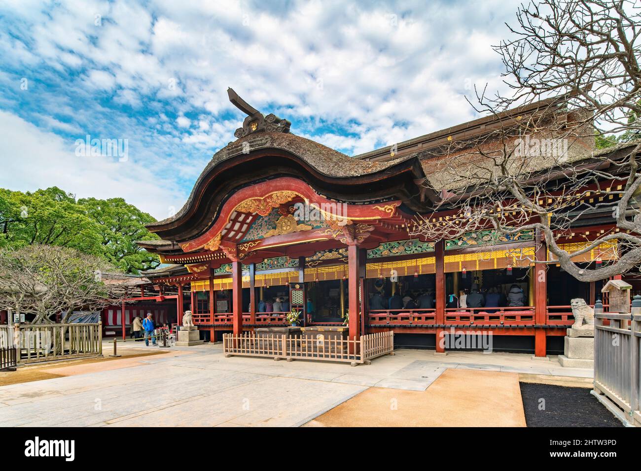 kyushu, fukuoka - dicembre 07 2019: I turisti che pregano nel santuario giapponese di Dazaifu dedicato a Sugawara no Michizane adorned con un roro di paglia ricurvo Foto Stock