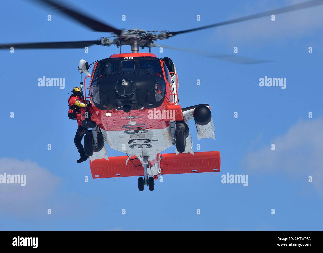 Petty Officer 3rd Classe James Lowen, un nuotatore di salvataggio presso Air Station Traverse City, si prepara a trasferire un sopravvissuto simulato in un MH-60 Jayhawk durante un'esercitazione di salvataggio su ghiaccio di massa presso il porticciolo municipale di Petoskey il 26 febbraio 2022. L'esercizio, che simulava il crollo di un aereo pendolari su Little Traverse Bay, ha attirato più di 100 soccorritori e membri della Guardia Costiera da tutto il Michigan settentrionale. Foto della Guardia Costiera statunitense di John Masson, Chief Petty Officer. Foto Stock