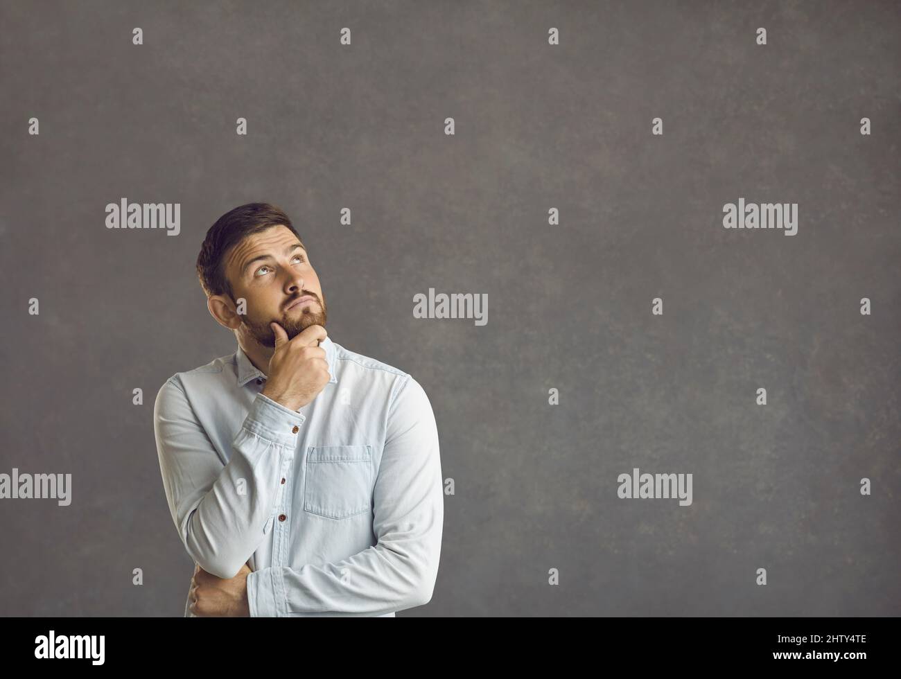 Ritratto di un uomo casual pensivo che guarda di lato Foto Stock