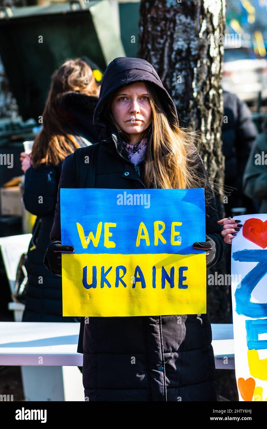 Bella ragazza durante una manifestazione pacifica contro la guerra, Putin e la Russia a sostegno dell'Ucraina, con persone, cartelli e bandiere. Stop War Foto Stock