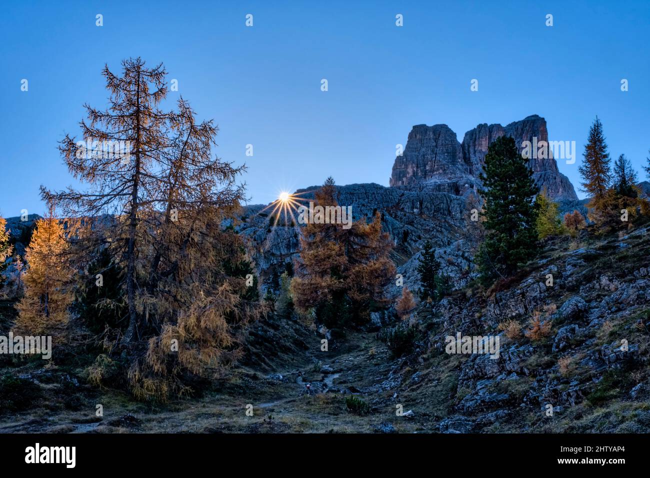 Il sole sorge accanto alla cima del Monte Averau, vista dal Lago di Limedes, in autunno. Foto Stock