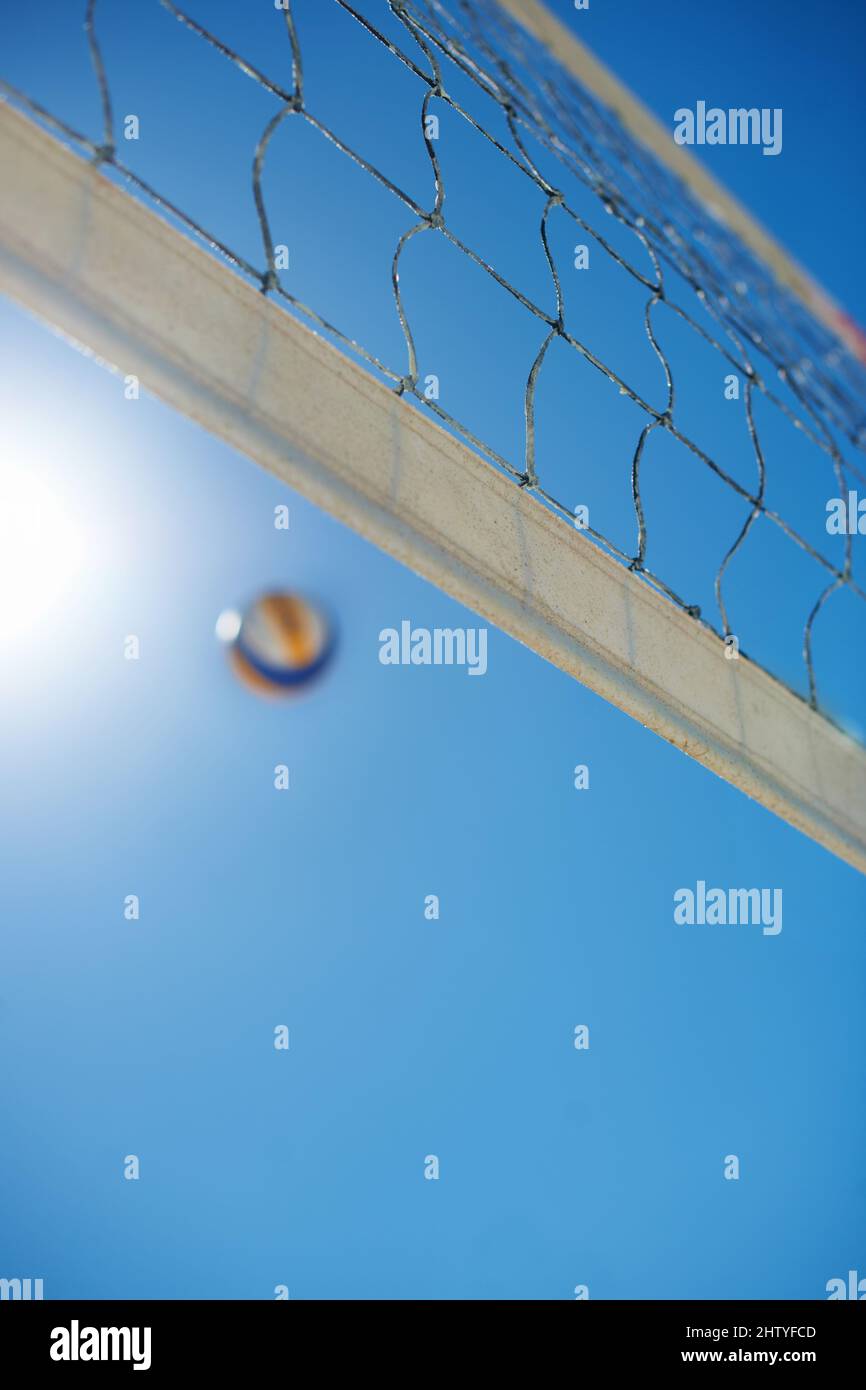 È un ritorno elevato. Scatto di una partita di Beach volley in una giornata di sole. Foto Stock