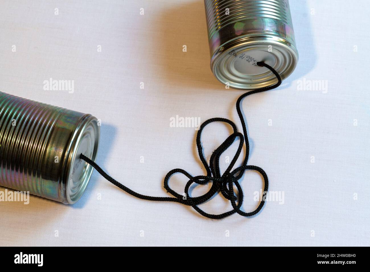Vista dall'alto di due lattine con un cordone tra loro aggrovigliato in su suggerendo breakdown di comunicazione.orientamento orizzontale Foto Stock