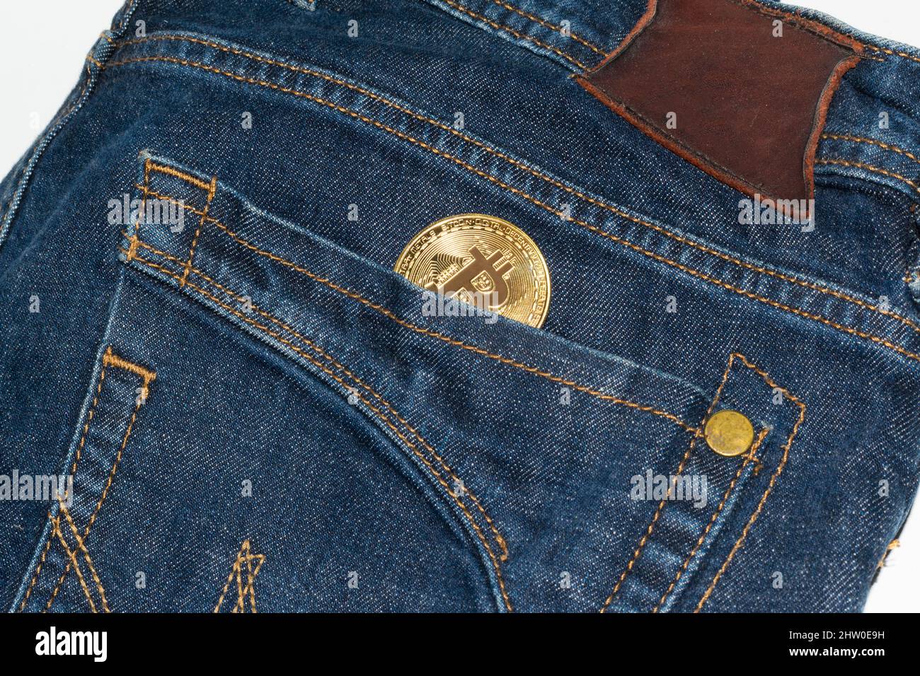 Moneta d'oro Bitcoin in tasca jeans Foto Stock