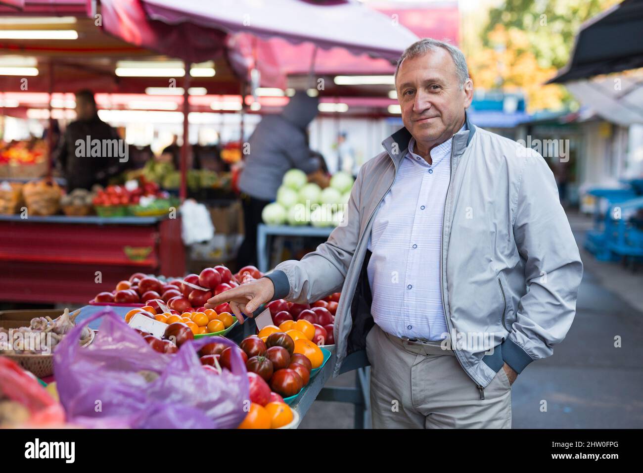 Uomo che sceglie le verdure in greengrocery Foto Stock