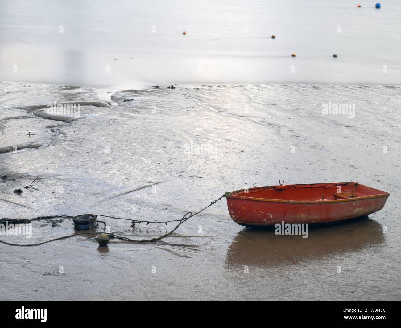 Piccolo rosso tenero, barca a remi, su fango, marea fuori. Foto Stock