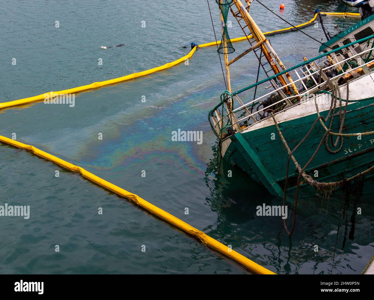 Pesca devastata Trawler perdite di olio con il boom antinquinamento in posizione Foto Stock