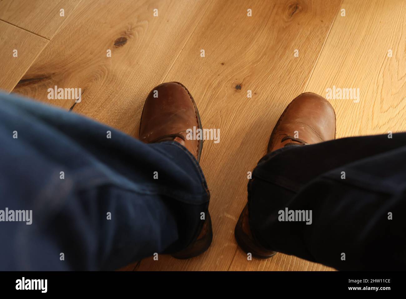 Gambe in jeans blu sotto il tavolo. Foto Stock