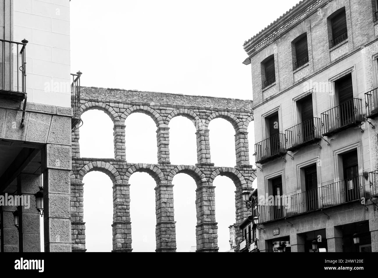 Una vista parziale dell'acquedotto romano (ponte dell'acquedotto) a Segovia circondato da edifici moderni. Foto Stock
