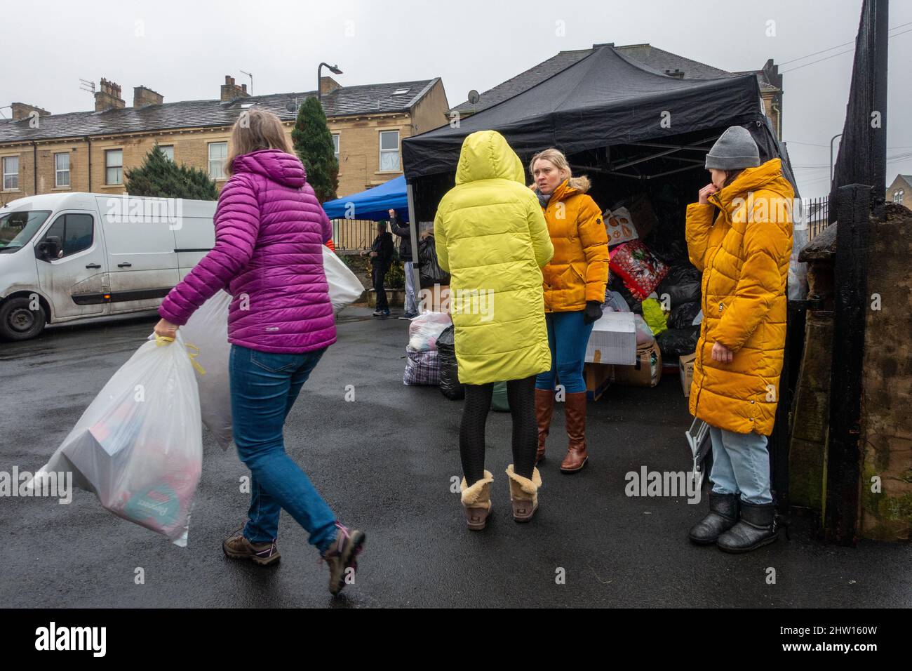 Russia Ucraina guerra. Persone che abbandonano donazioni a una chiesa polacca a sostegno dei rifugiati ucraini al confine con la Polonia. Furgone sullo sfondo è pieno al tetto di forniture urgenti e parte lo stesso giorno. Bradford, West Yorkshire, Inghilterra, Regno Unito Foto Stock