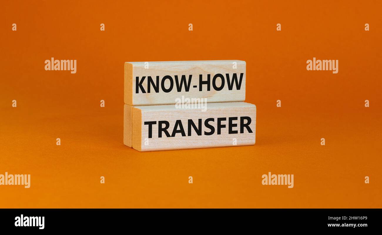 Simbolo di trasferimento del know-how. Concetto parole know-how trasferimento su blocchi di legno su bello arancione tabella sfondo arancione, spazio copia. Business, innovazione Foto Stock