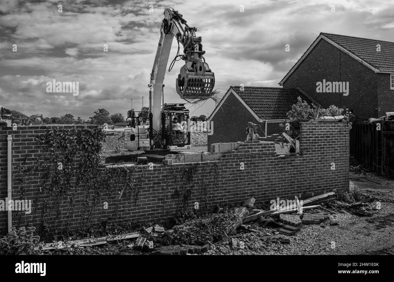 Macchinario per impieghi pesanti con operatore demolire garage e casa a fare il posto per lo sviluppo di nuovi supermercati vicino Minster Way, Beverley, Regno Unito. Foto Stock