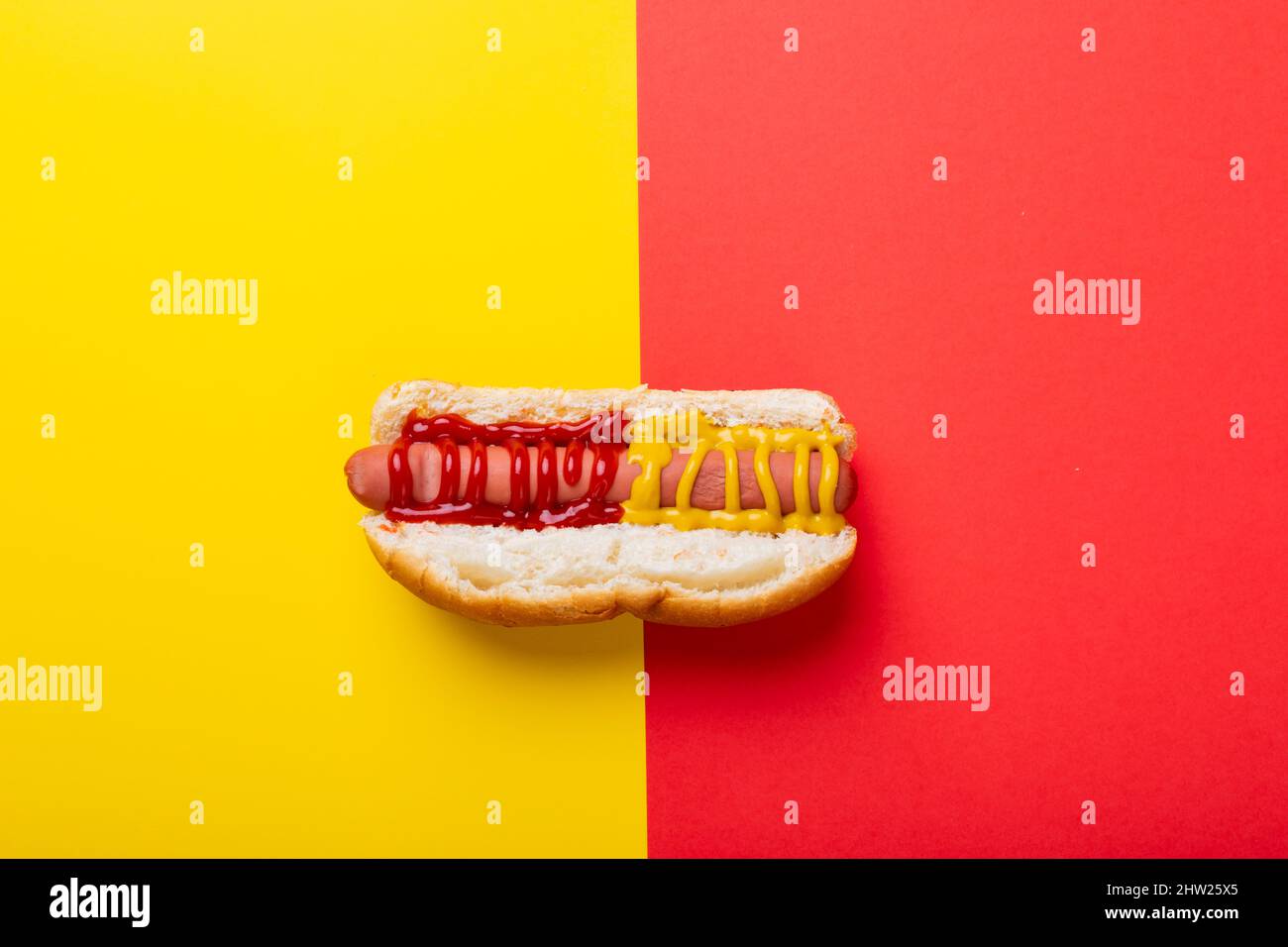 Hot dog con salsa di pomodoro e mostered su sfondo a due toni con spazio copia Foto Stock