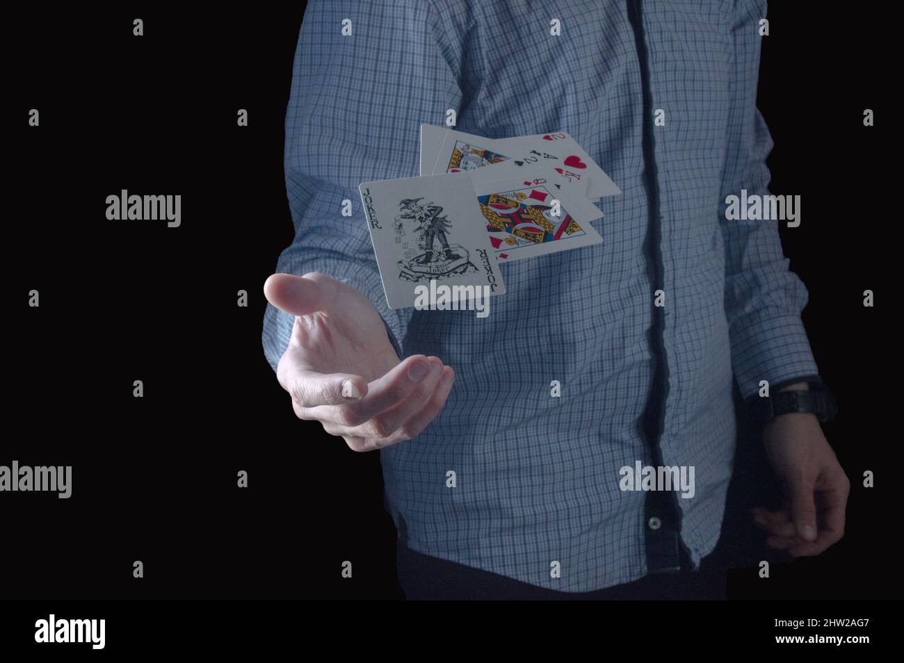 Un uomo lancia carte da gioco. Mano e carte da gioco. Scherzo nero sulla  scheda. Uomo in camicia Foto stock - Alamy