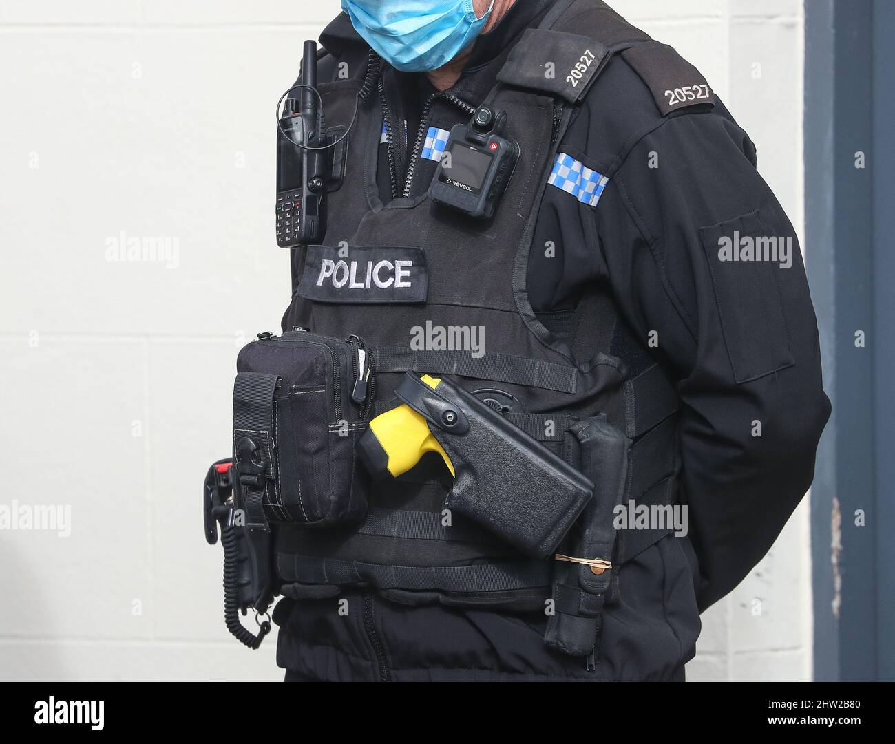 Ufficiale di polizia del Regno Unito che indossa un giubbotto tattico, tra cui una pistola da tazer e una macchina fotografica per il corpo. Foto Stock
