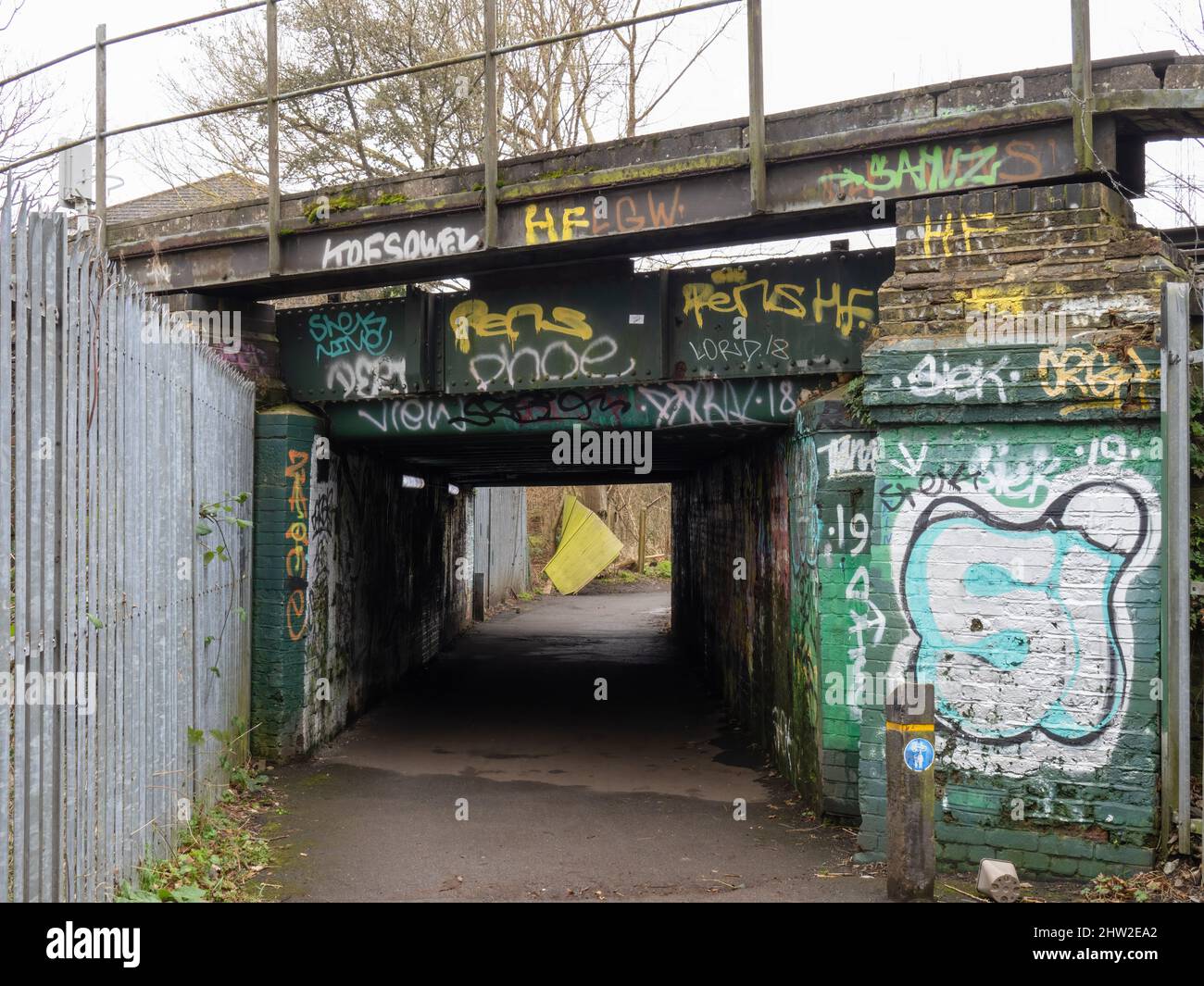LONDRA, INGHILTERRA - FEBBRAIO 20 2022: Ambiente urbano, vecchio sottopassaggio scruffy con graffiti e recinzione rotta oltre. Foto Stock