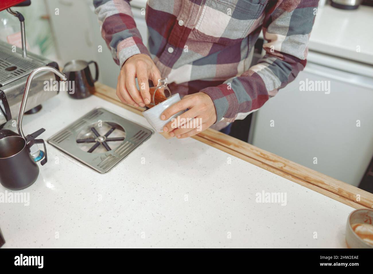 Primo piano delle mani maschili del barista che prepara il caffè Foto Stock