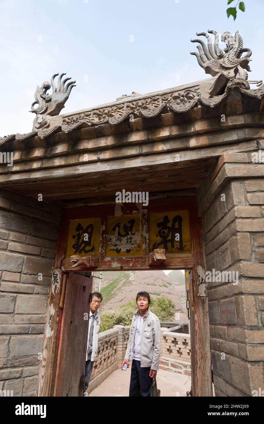 I visitatori ammirano il tradizionale stile ornamentale porta d'ingresso / porta d'accesso arco all'interno del complesso Water Curtain Cave, noto anche come Shuilian Dong, che si trova in: Contea di Wushan, Gansu, Tianshui, Gansu, Cina, 741306. PRC Foto Stock