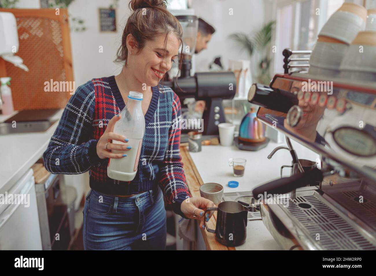 Barista signora sorridente che prepara il caffè in un caffè Foto Stock