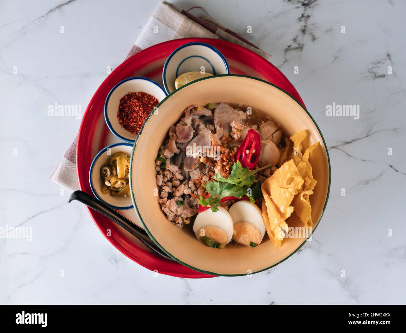 Thai Food Sukothai scarabine di maiale in un piatto isolato sul tappeto vista dall'alto su sfondo di marmo grigio Foto Stock