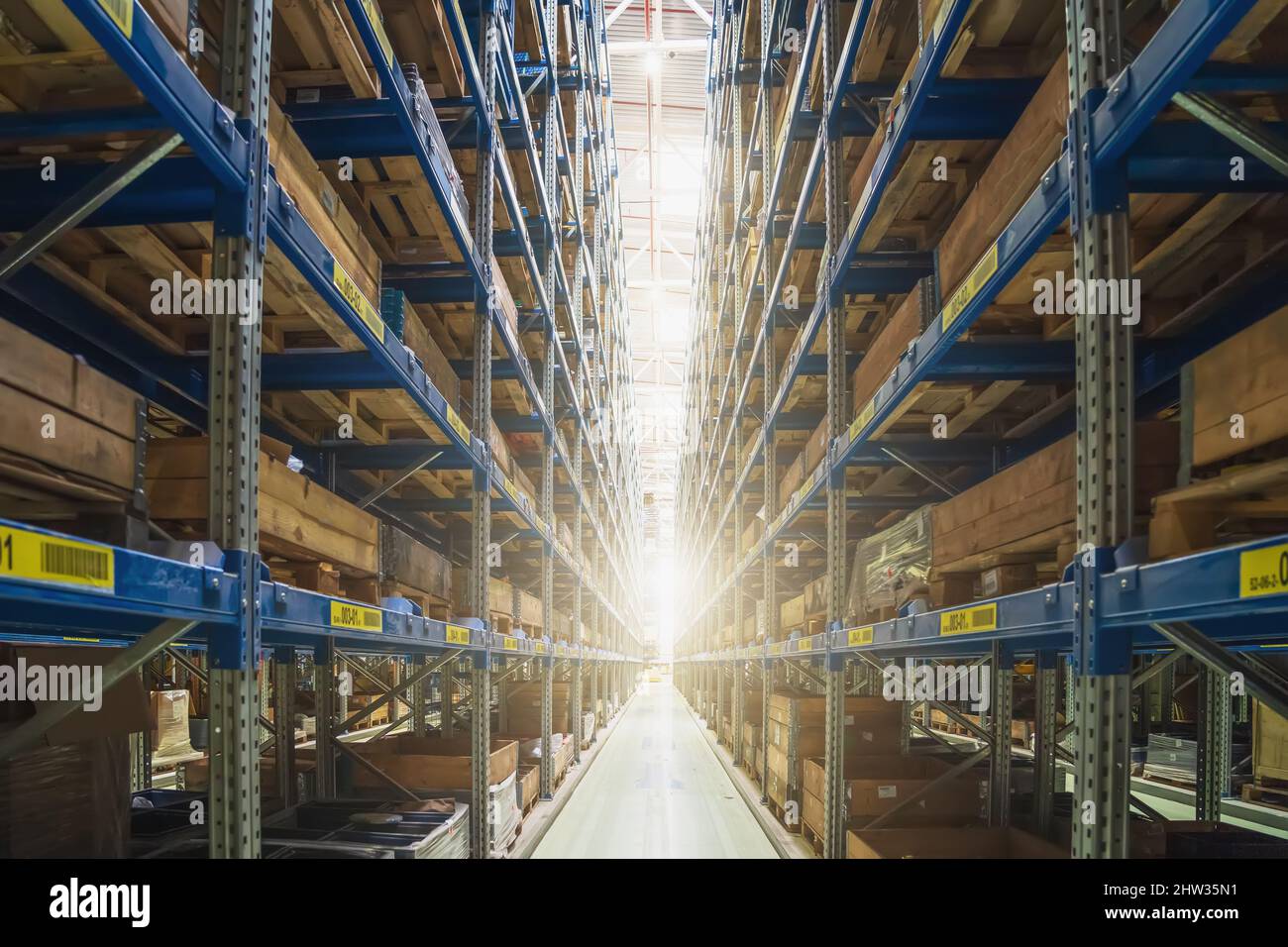 Enorme magazzino industriale moderno, vista corridoio con luce in fine. Merci e prodotti scatole pronte per la distribuzione e logistica. Foto Stock