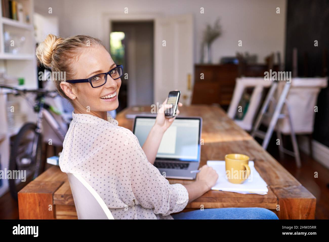 Rende semplice il multitasking. Un ritratto di una bella giovane donna che lavora da casa. Foto Stock