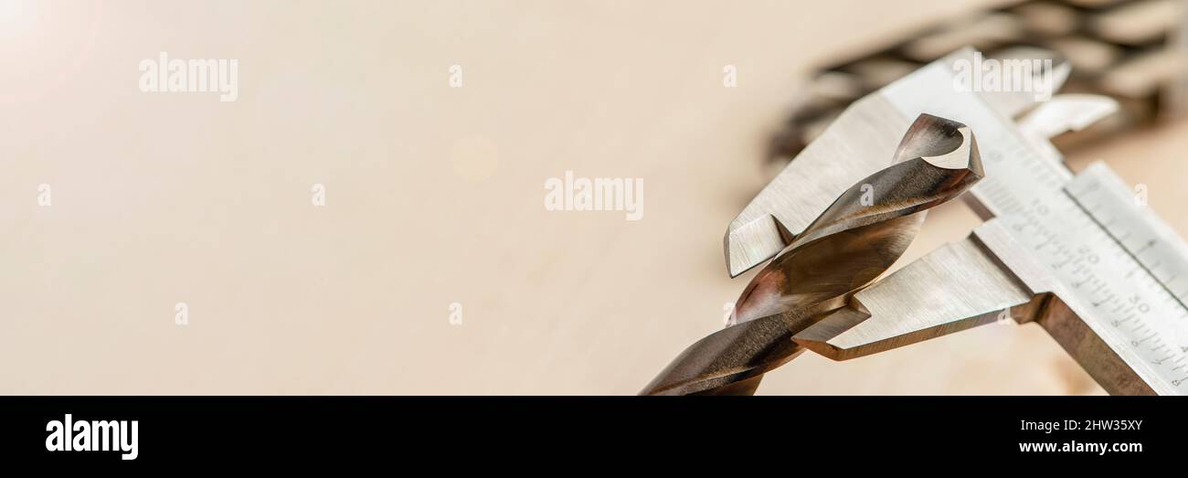 la pinza misura la punta su metallo, misura lo spessore dell'utensile di foratura in una macchina da perforazione industriale. Industria metallurgica Foto Stock