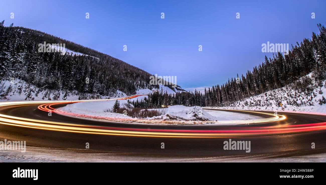 Le luci dalle automobili un blurred come la velocità intorno ad un tornante girano sul passo di Berthoud vicino a Winter Park, Colorado Foto Stock