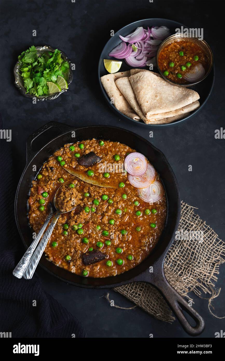 Curry di cheema di carne tritato a cottura lenta con piselli e pane indiano Foto Stock