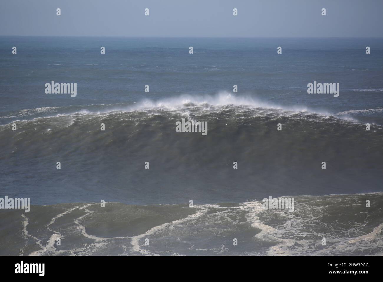 Navigazione non identificata un'onda gigante nella spiaggia Nord di Nazaré (Praia do Norte), in Portogallo. Foto Stock