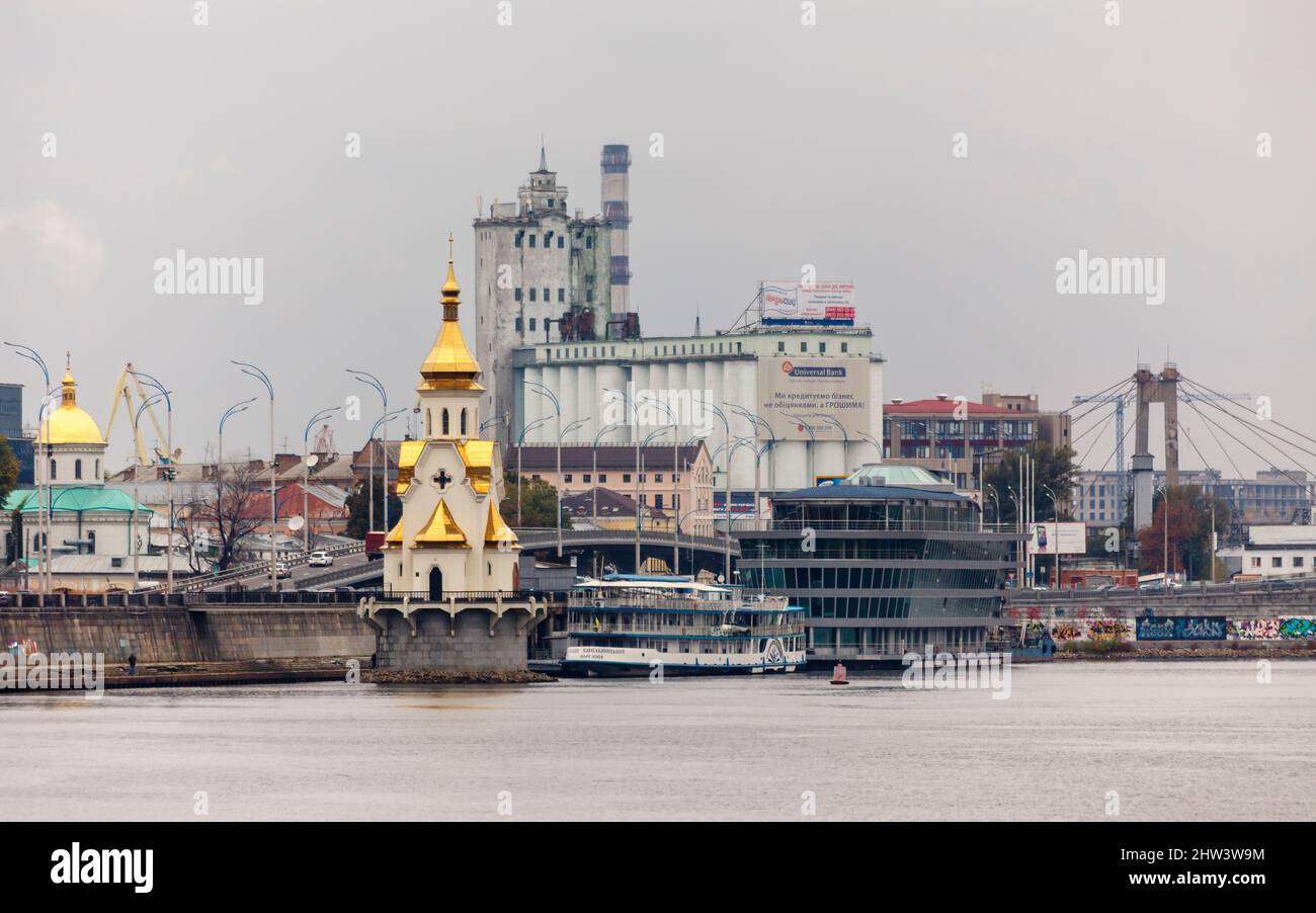 St Nicholas la chiesa ortodossa di Wonderworker e il lungomare sul fiume Dnieper nel distretto di Podil in una giornata noiosa, Kiev (Kiev), capitale dell'Ucraina Foto Stock