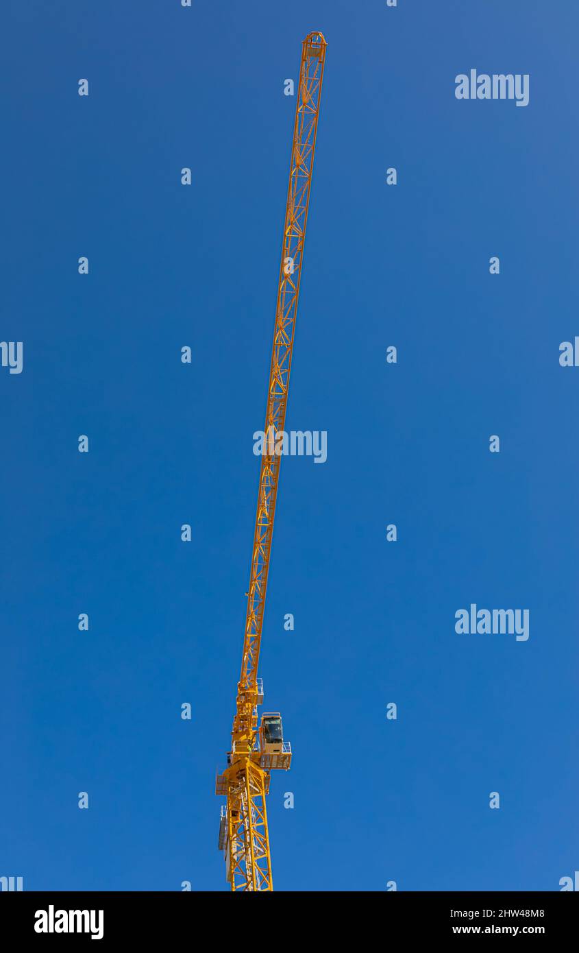 Alta gru da sola contro il cielo blu. Grandi alti crins sotto un nuovo luogo di costruzione. Nessuno, fuoco selettivo, spazio di copia per il testo Foto Stock