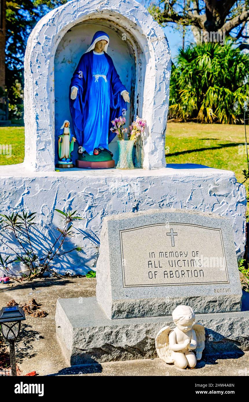 Una statua della Vergine Maria si trova accanto a un monumento alle vittime dell'aborto presso la chiesa cattolica di Santa Margherita a Bayou la Batre, Alabama. Foto Stock