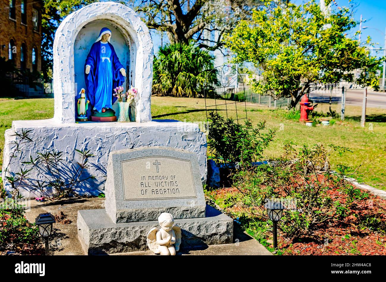 Una statua della Vergine Maria si trova accanto a un monumento alle vittime dell'aborto presso la chiesa cattolica di Santa Margherita a Bayou la Batre, Alabama. Foto Stock