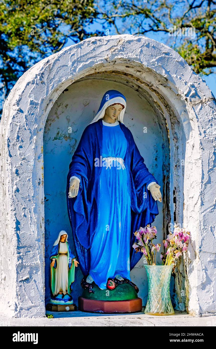 Una statua della Vergine Maria si trova accanto a un monumento alle vittime dell'aborto presso la chiesa cattolica di Santa Margherita a Bayou la Batre, Alabama. Foto Stock