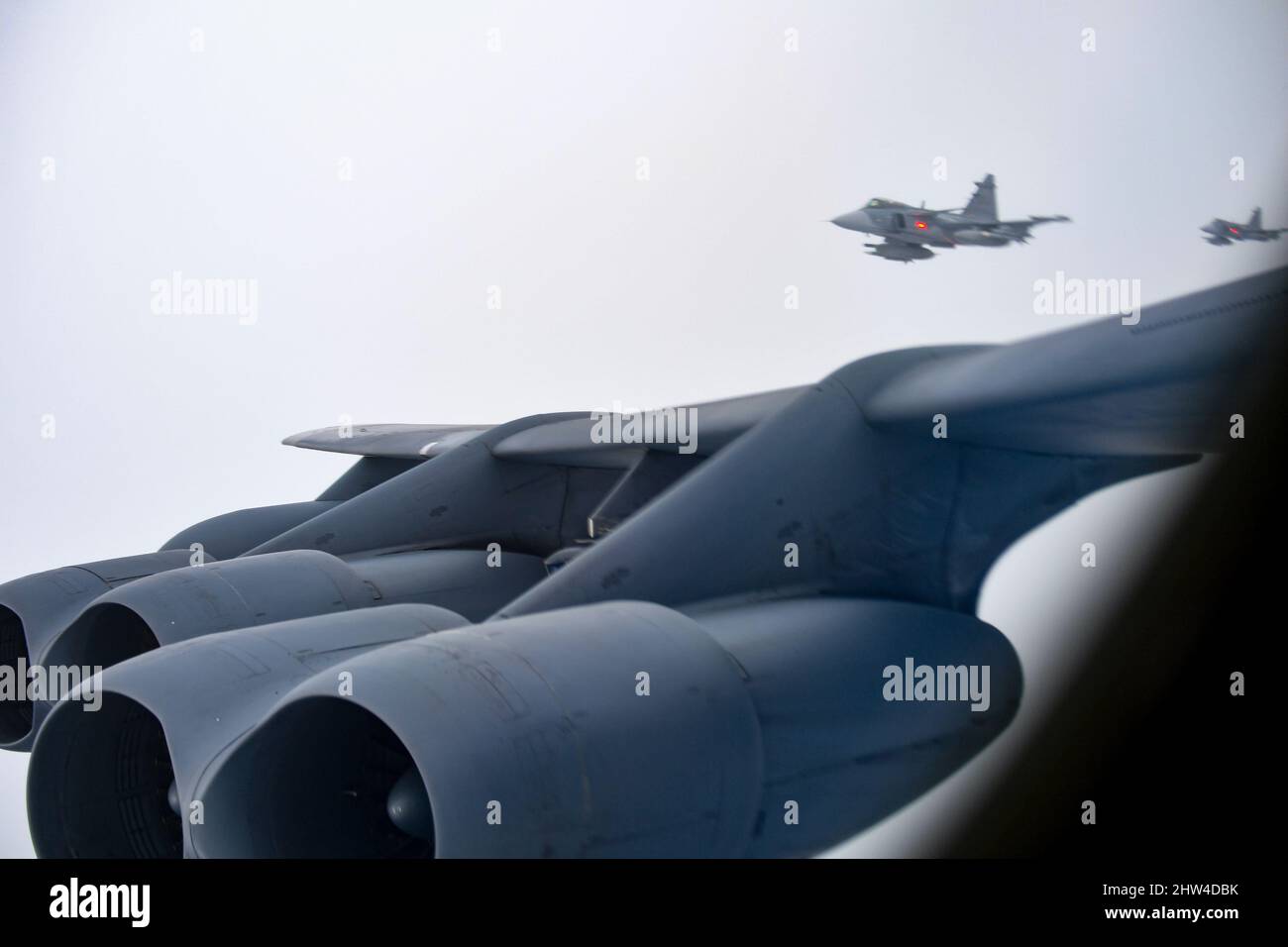 Due aerei da caccia Svedese Saab JAS-39 Gripen scortano uno stratofortress B-52H, assegnato allo Squadrone della bomba di spedizione 69th, RAF Fairford, Inghilterra, oltre la Svezia, durante la Bomber Task Force Inghilterra il 24 febbraio 2022. L'aeronautica svedese si è incontrata con il B-52 per impegnarsi in scenari di addestramento al fine di rafforzare l'interoperabilità tra le due forze. (STATI UNITI Air Force foto di Tech. SGT. Corban Lundborg) Foto Stock